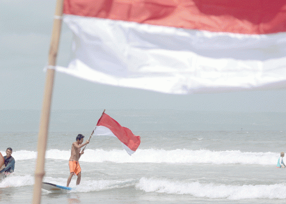 Nusabali.com - meriahkan-hari-kemerdekaan-surfing-sambil-kibarkan-bendera