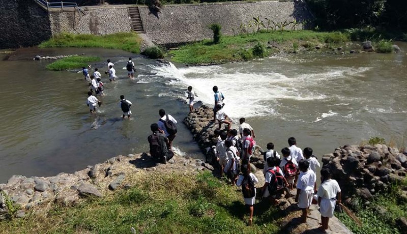 www.nusabali.com-berangkat-sekolah-siswa-sdn-5-ringdikit-mesti-seberangi-sungai